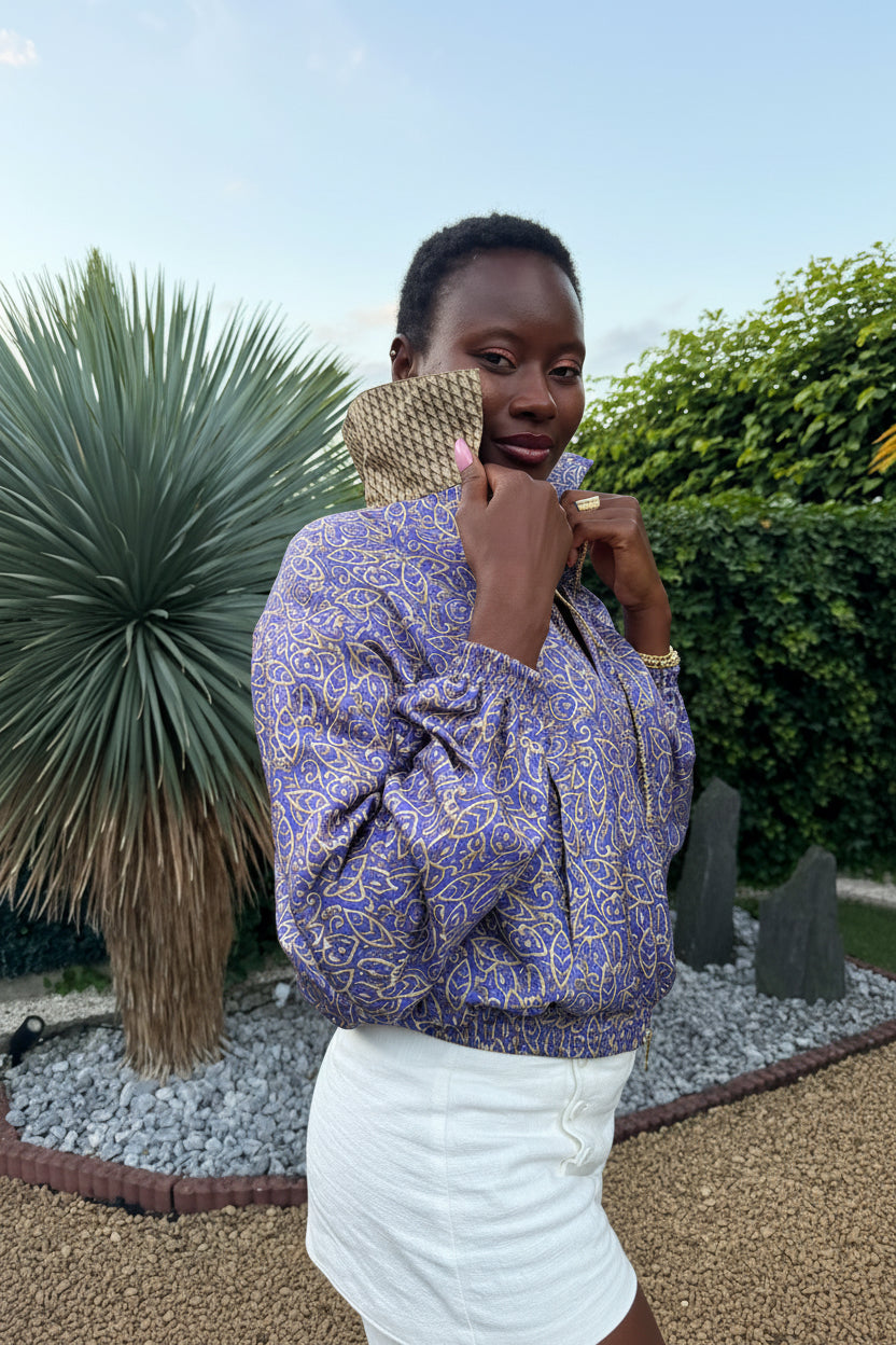 Femme portant un bomber violet floral en sari recyclé dans un jardin