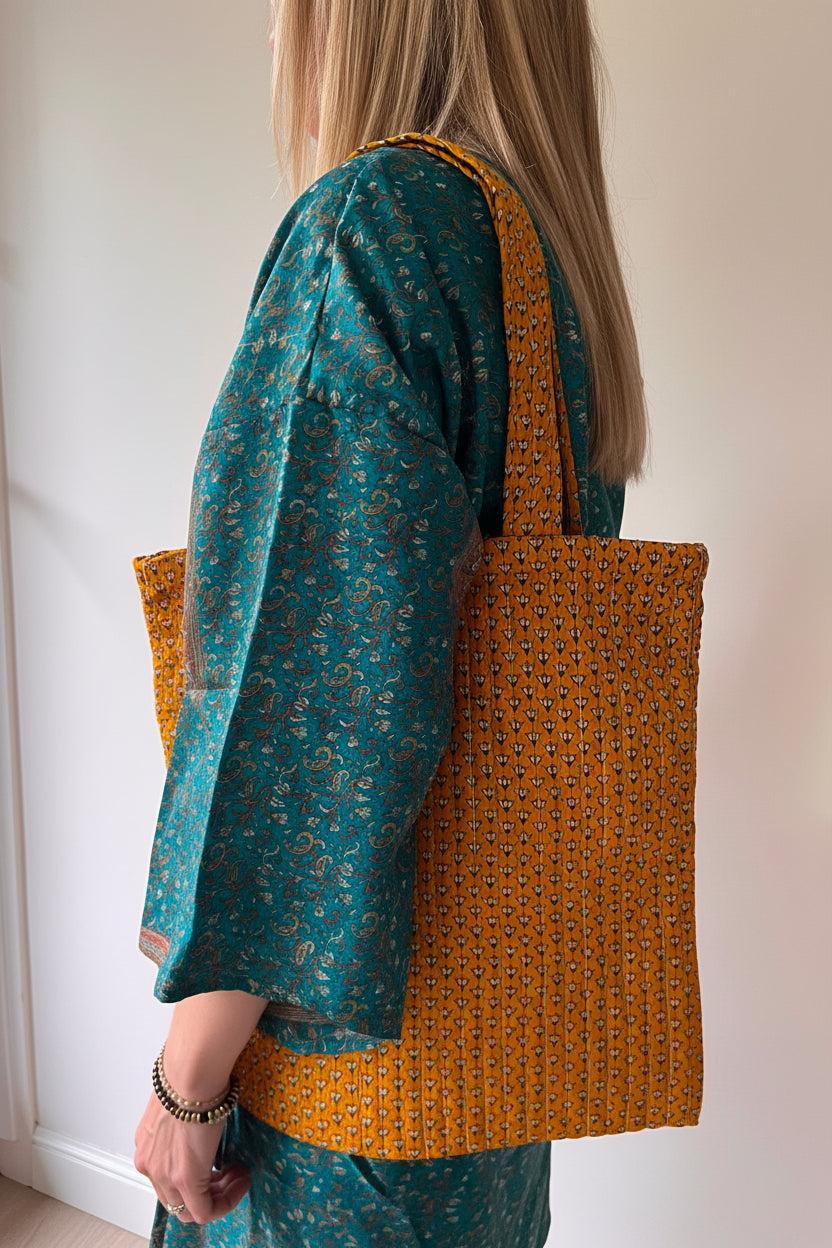 Sac cabas en sari recyclé ocre porté à l'épaule, accessoire bohème artisanal et écoresponsable.