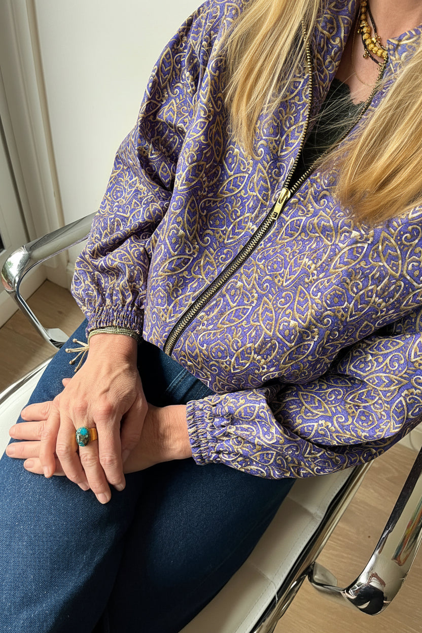 Femme assise portant un bomber violet floral fabriqué à partir d’un sari recyclé