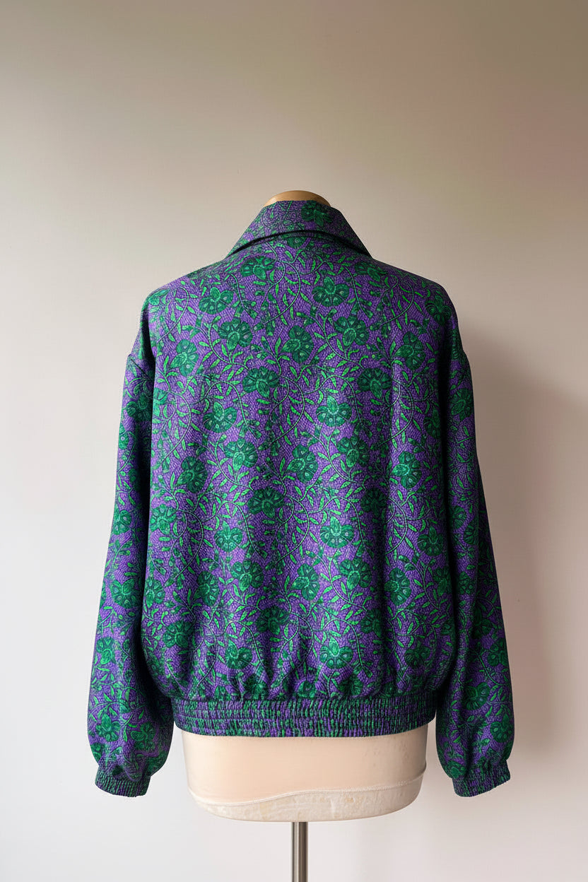 Vue de dos d'un bombers femme violet à motif floral vert avec col chemise et taille élastiquée.
