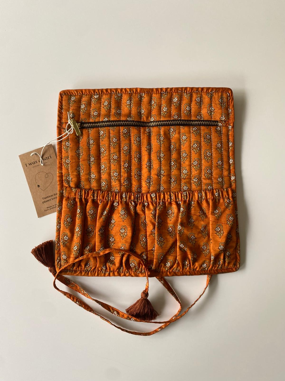 Pochette en sari recyclé ocre et terracotta ouverte pour ranger bijoux et accessoires