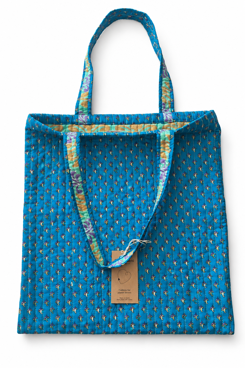 Sac cabas en sari indien recyclé bleu turquoise à motifs ocre, avec étiquette suspendue à l’anse.
