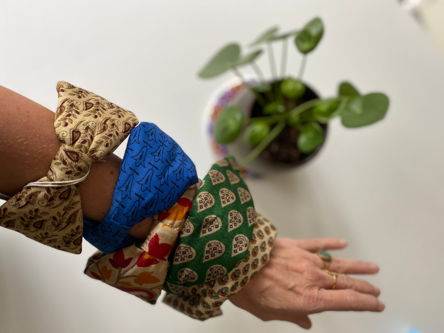 Serre-tête en sari recyclé écru à motifs floraux présenté avec plusieurs modèles de la collection