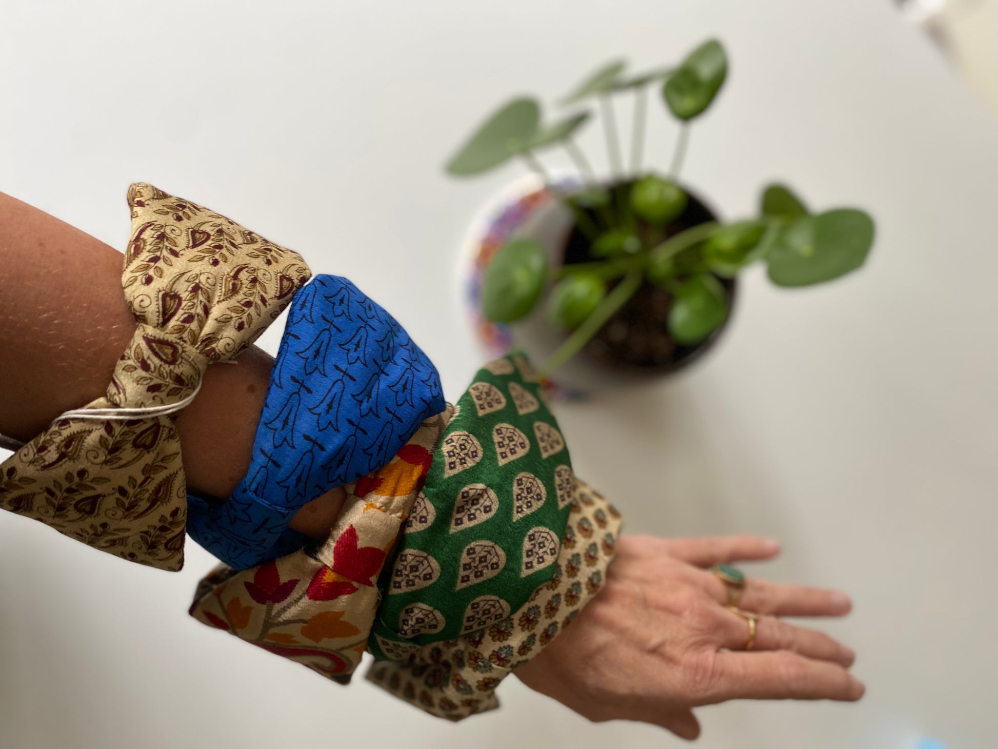 Serre-tête en sari recyclé écru à motifs floraux présenté avec plusieurs modèles de la collection
